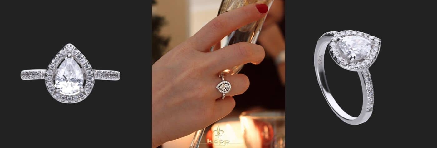 Frau trägt einen Ring am Finger und hält ein Glas in der Hand sie hat rote Fingernägel